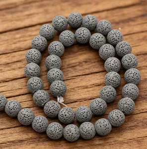 Nahaufnahme grauer poröser Lavasteinperlen, natürliche Vulkangesteinstruktur für DIY-Schmuck.