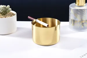 Moderne minimalistische roestvrijstalen asbak, gouden geborstelde afwerking, bureaudetail