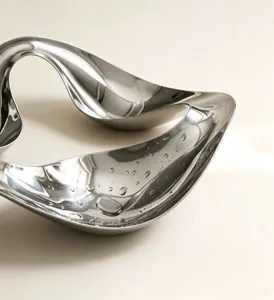 Close-up shot of Nordic fluid metal tray, elegant curve for modern jewelry decor details.