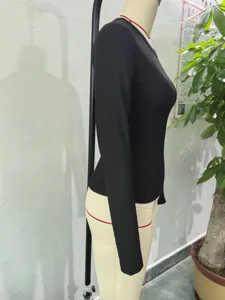 Side view detail of a black ribbed long sleeve top, slim fit crew neck basic layering shirt.