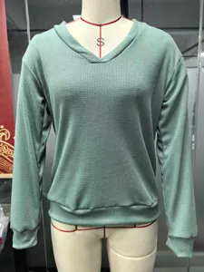 Detailed view of women waffle knit V-neck long sleeve top in solid green casual style.