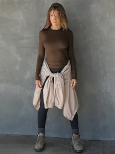 Detail view of the stylish brown ribbed long sleeve top worn by model in casual scene.