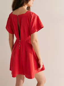 Detailed view of the red mini dress featuring a square neckline, short sleeves, and back button design.
