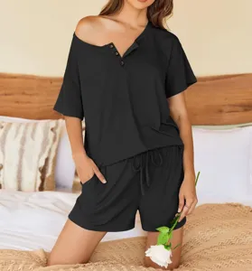 Detail view of a stylish black ribbed lounge set featuring an asymmetric button top and shorts.