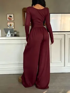 Detailed back view of casual long-sleeve wide-leg jumpsuit, solid burgundy fabric texture.