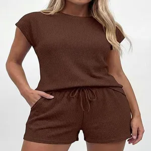 Détail d'ensemble lounge en tricot gaufré marron avec haut à manches courtes et short.
