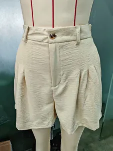Détail de short décontracté plissé taille haute beige, vêtement femme urbain élégant.