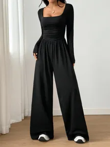 Detailed view of the black long sleeve square neck wide leg jumpsuit showcasing ruched waist.