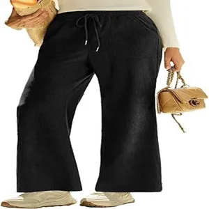 Dettaglio pantaloni larghi in velluto a coste nero, vita alta elastica con coulisse e tasche.