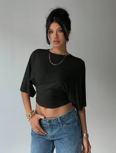 Detailed view of a trendy black cropped top featuring chic ruched waist design and sleeves.