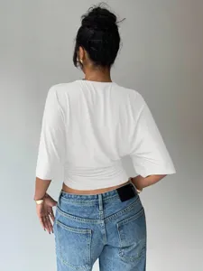 Back view of a white short sleeve crop top paired with blue jeans, slim fit daily casual wear.