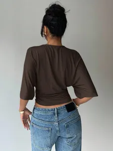 Women solid brown cinched waist short sleeve top paired with casual blue denim jeans.