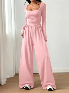 Detailed shot of the pink long-sleeve square neck jumpsuit showing ruched waist and wide leg.