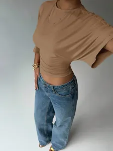 Close up detail view of the elegant beige waist cinching short sleeve top, featuring slim fit.