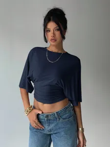 Close-up detail of the stylish draped short-sleeve top featuring a gathered waist design.