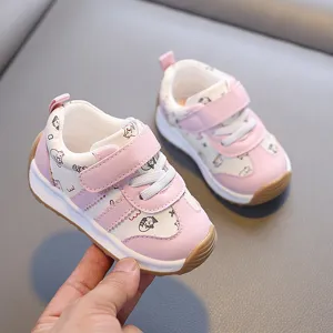 Gros plan détail de chaussures pour tout-petits rose et blanc avec de jolis imprimés de chats.