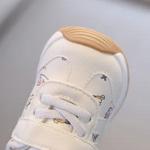 Gros plan détaillé de l'embout en cuir souple de la sneaker pour bébé avec des motifs mignons.