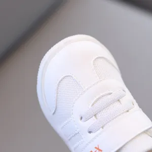 Primo piano sulla punta delle sneakers per bambini bianche, mesh traspirante e sintetico.