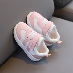 Vista dettagliata di scarpe da camminata rosa e bianche per neonati con suola morbida e velcro.
