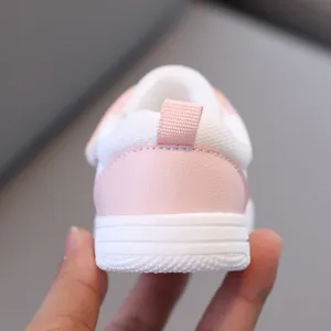 Primo piano sul tallone della sneaker per bambini con linguetta rosa e suola flessibile.