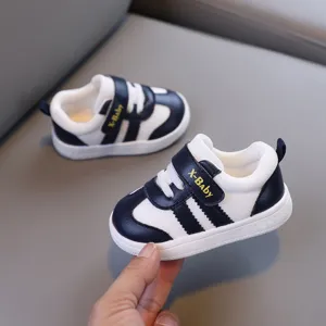 Scarpe primi passi dettaglio, design contrasto bianco e blu scuro, suola morbida per bambini.