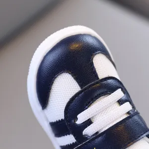 Scarpa bimbo dettaglio rete, sneaker blu navy e bianca primo piano, suola morbida vista.
