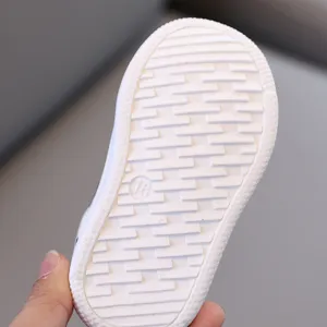 Vista inferiore dettagliata di scarpe sportive antiscivolo per bambini con suola testurizzata.