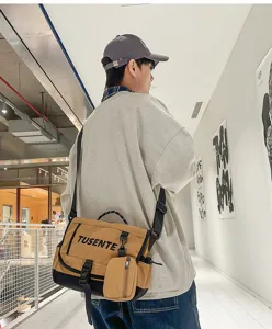 Bolso mensajero de lona informal estilo utilitario con correa ajustable y bolsillo.