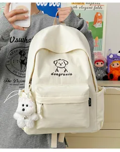 Cute beige canvas school backpack detail showing embroidery graphic and fluffy dog pendant.