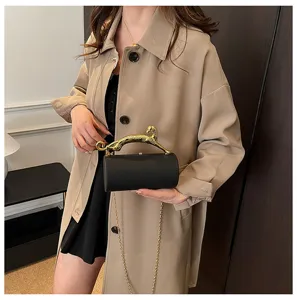 Elegant black acrylic cylinder evening bag with gold leopard handle and chain strap for women.