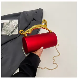 Red acrylic cylindrical evening clutch bag featuring a luxurious gold leopard handle and chain strap.