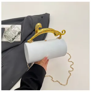 Detail view of white acrylic cylindrical evening clutch bag with gold leaping panther handle.
