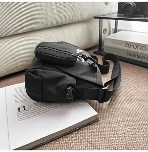Vista detallada del bolso mensajero negro minimalista, bolso cruzado unisex estilo urbano.
