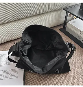 Detalle interior del bolso bandolera negro con tejido resistente y compartimento de malla.