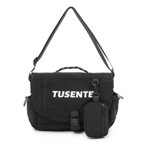 Detalle de la bolsa mensajero negra con tela resistente, bolsillo frontal y correa ajustable.