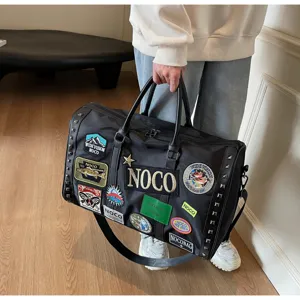 Μεγάλη τσάντα ταξιδιού με μοντέρνα patches και μεταλλικές τσόκες, κομψή μαύρη τσάντα ώμου.