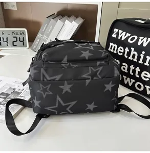 Gedetailleerd uitzicht op zwarte studentenrugzak met stijlvol wit sterrenpatroon voor school.