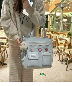 Vista dettagliata della borsa tote da studente azzurro stile Harajuku con tasche e ciondoli.