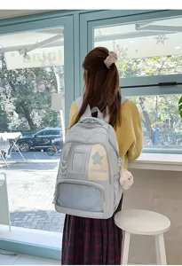 Détail de sac à dos scolaire mignon avec fenêtre transparente, patch étoile et grande capacité.