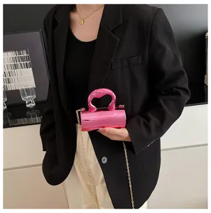 Shiny pink PVC cylindrical mini handbag with chain strap, stylish detail view for women.