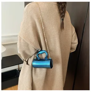 Glossy blue PVC cylinder crossbody bag featuring a chic gold chain strap for women detail view.