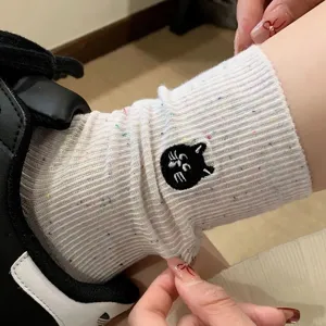 Close-up detail of cute women autumn winter crew socks featuring black cat embroidery design.