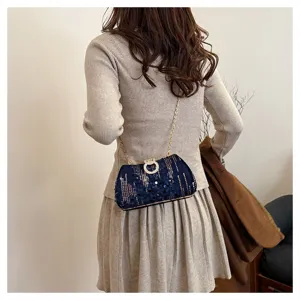 Detailed view of dark blue sequin evening bag with elegant chain and sparkling rhinestone ring.