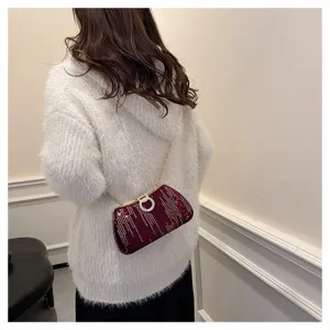 Detailed view of the elegant maroon sequin evening bag with sparkling rhinestones and chain strap.