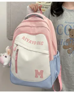 Detailansicht des bunten Colorblock-Schulrucksacks mit praktischer Fronttasche und süßem Anhänger.