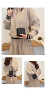 Primo piano dettagliato della mini borsa a catena in rete nera indossata dalla modella, texture.