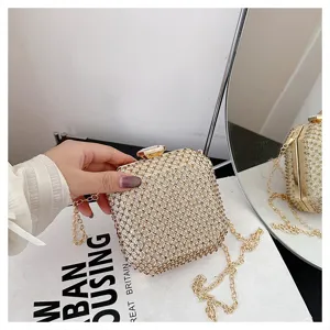 Primo piano di una mini pochette scintillante in strass con catena dorata e chiusura elegante.