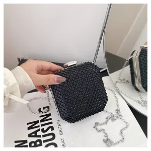 Primo piano della mini borsa a catena in rete di strass nera, squisita texture fine.