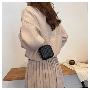 Vista dettagliata di una mini borsa a catena in rete nera con preziosa trama di strass.