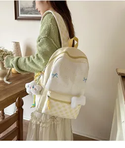 Detailansicht eines niedlichen japanischen Karo-Schulrucksacks mit süßem Stickerei-Zitat.